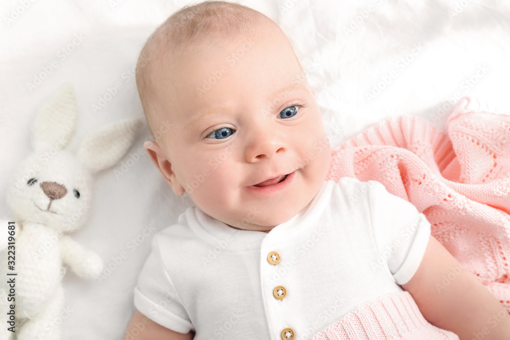 Portrait of cute little baby lying on bed