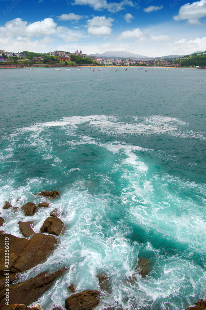 Ocean wave crashing on rock in the bay