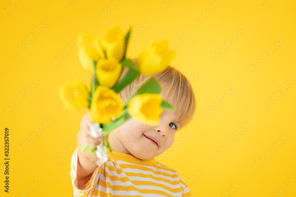 Happy child holding spring bouquet of flowers