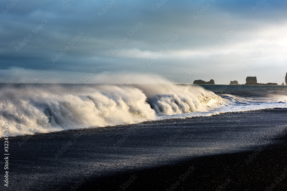 Gorgeous landscape with large waves on Black beach. Stormy Atlantic ocean waves and cloudscape. Reyn