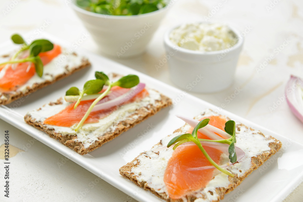 Sandwiches with tasty cream cheese and salmon on plate