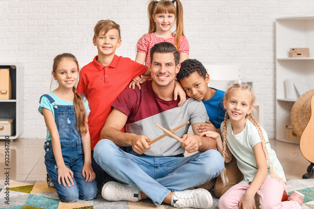 Music teacher with little children at school