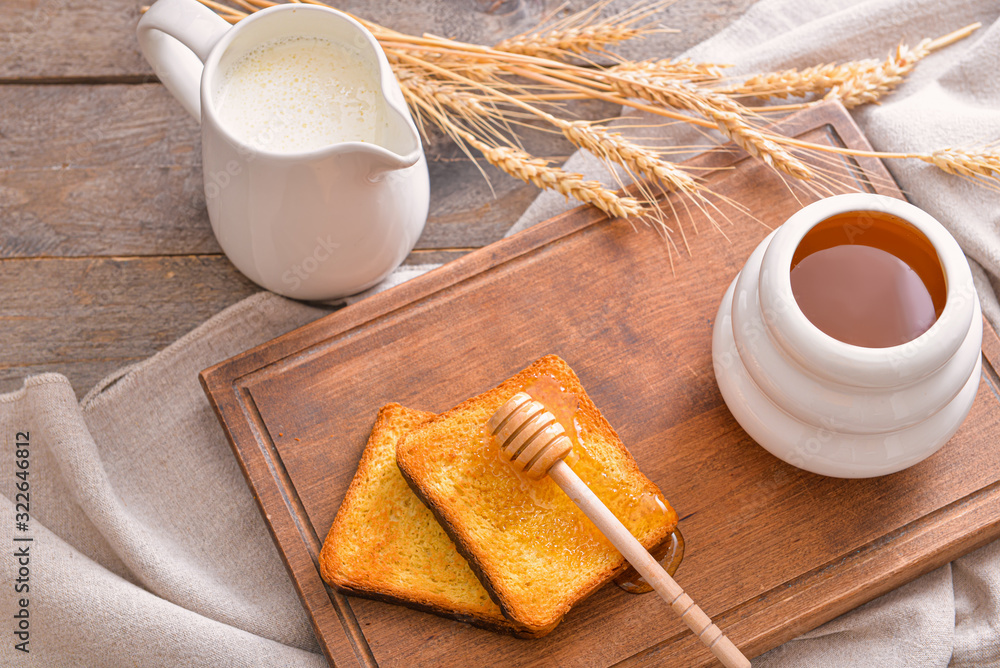 Sweet honey, milk and toasted bread on table