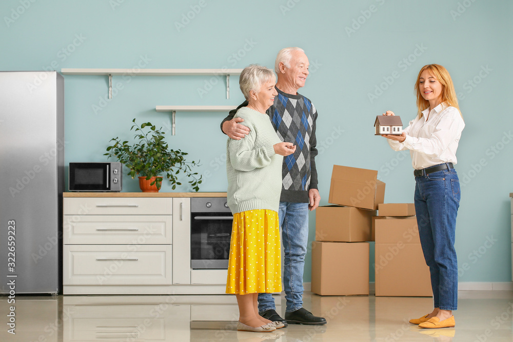 Female real estate agent working with senior couple indoors