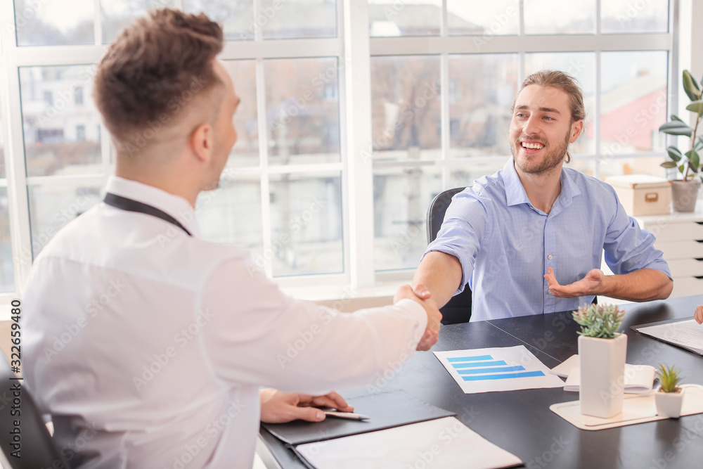 Human resources manager shaking hands with applicant after successful interview