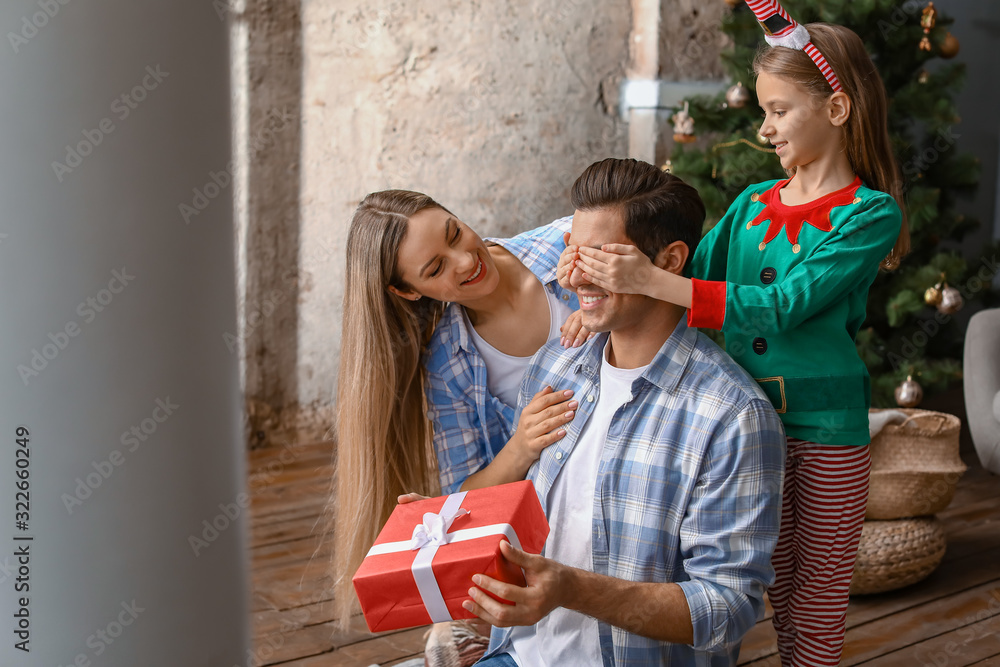 Wife and daughter greeting man on Christmas at home