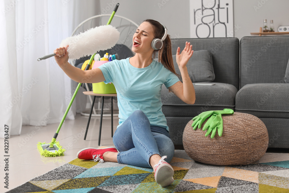 Young housewife having fun while cleaning her flat