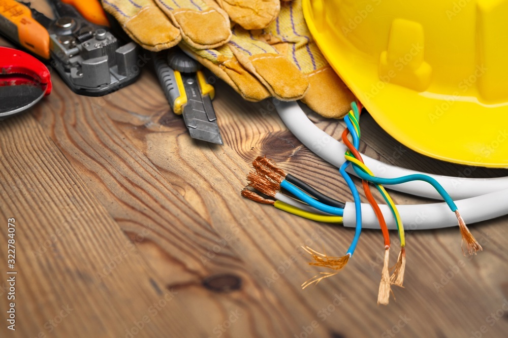 Yellow hard hat and leather work gloves on wooden desk