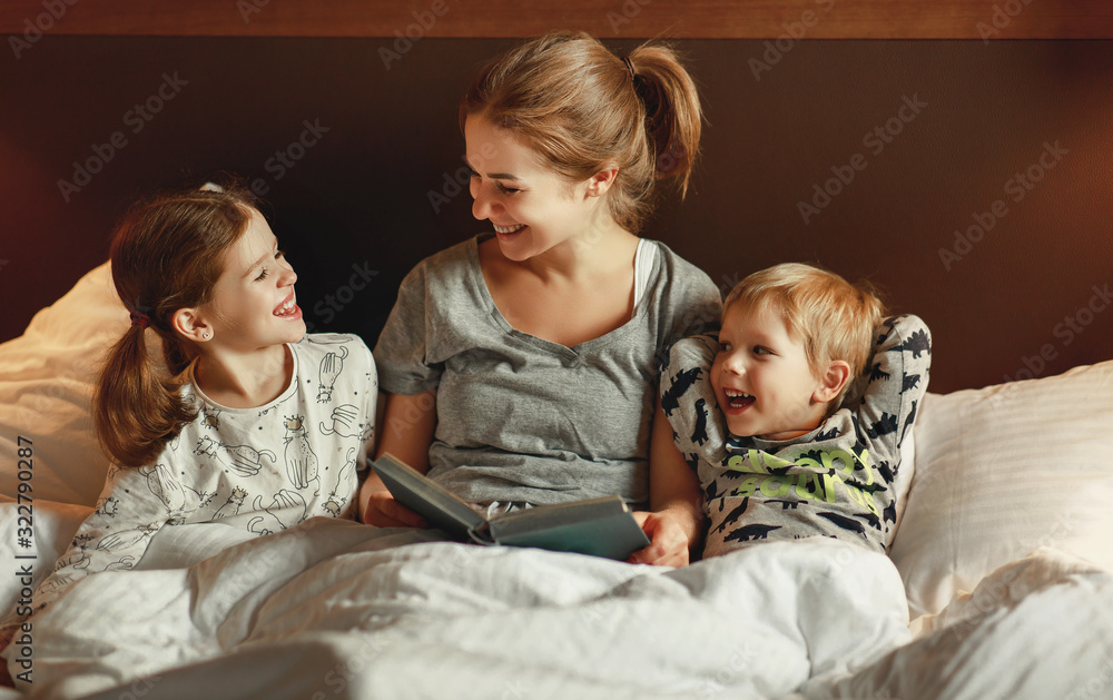 evening family reading. mother reads children . book before going to bed .