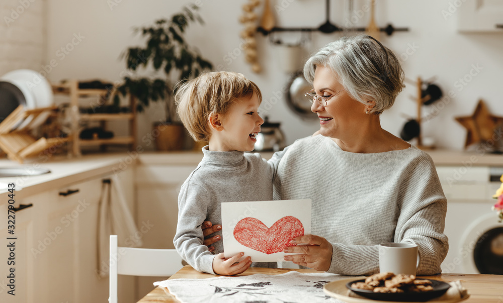 happy family grandson child congratulates grandmother on holiday and gives card