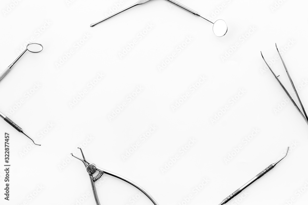 Stomatological tools on dentists desk on white background top-down frame copy space