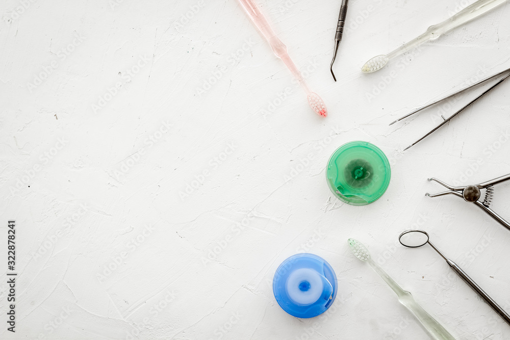 Dental care concept. Stomatological tools frame - with floss - on white background top-down frame co