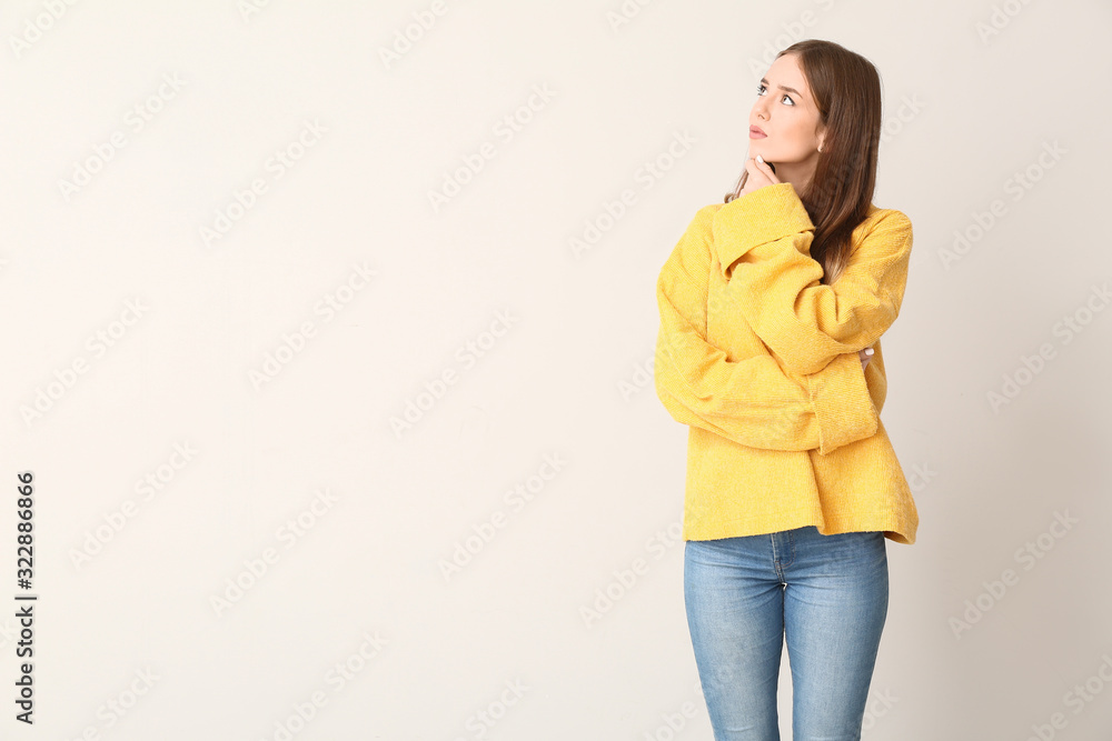 Thoughtful young woman on light background. Concept of choice