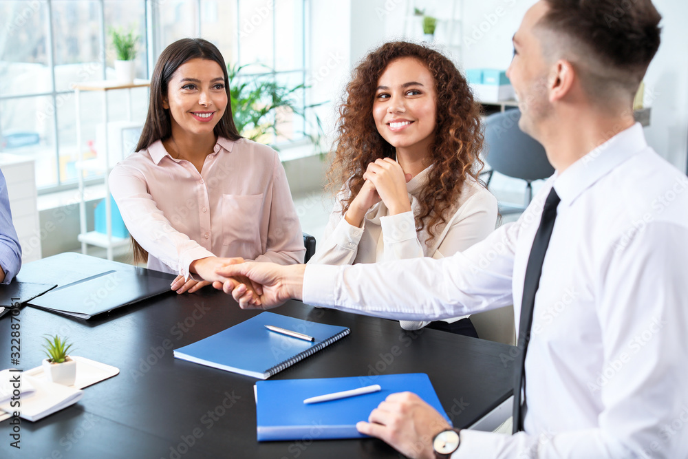 Human resources manager shaking hands with applicant after successful interview