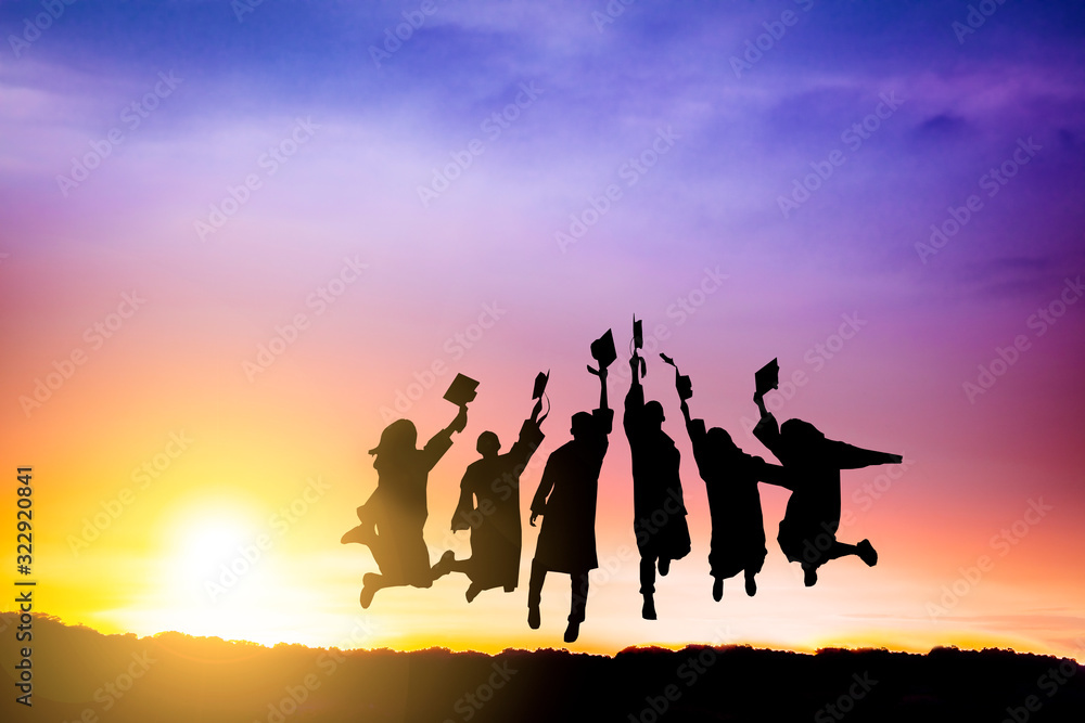 The Silhouette of  graduation group celebrating and jumping on mountain