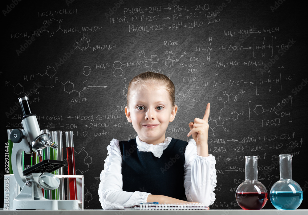 Little girl scientist sitting at desk