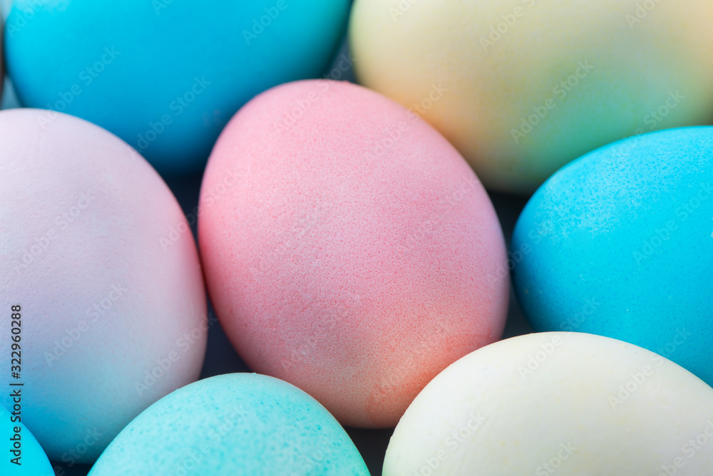 Colorful Easter eggs dyed by colored water isolated on a pale blue background, design concept of Eas