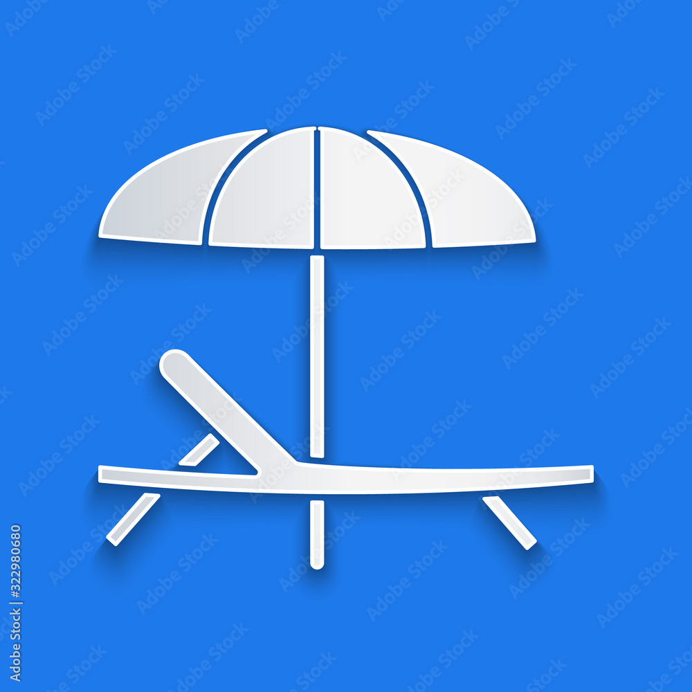 Paper cut Sunbed icon isolated on blue background. Beach umbrella and Sun lounger. Paper art style. 