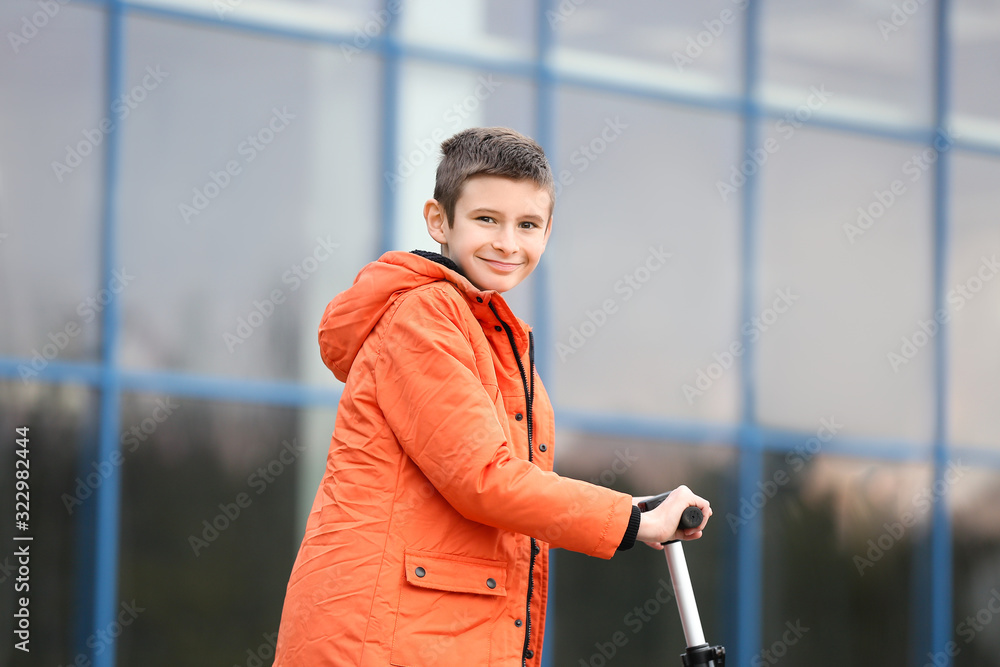 Teenage boy riding kick scooter outdoors