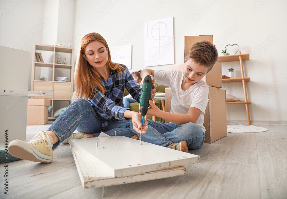 Mother and her little son assembling furniture at home