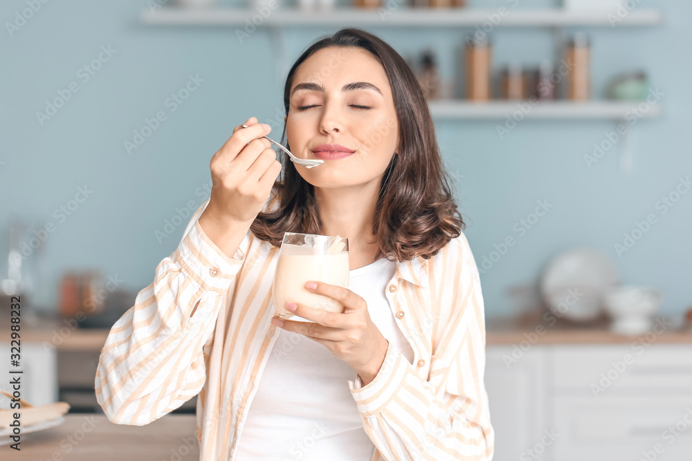 年轻女人在家吃美味的酸奶