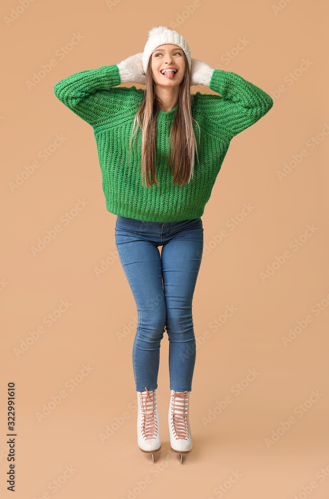 Funny young woman on ice skates against color background