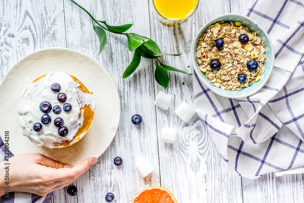 Breakfast concept with flowers on wooden background top view