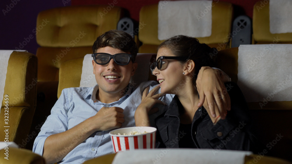 Man and woman in the cinema watching a movie with 3D glasses. with interest looking at the screen, e