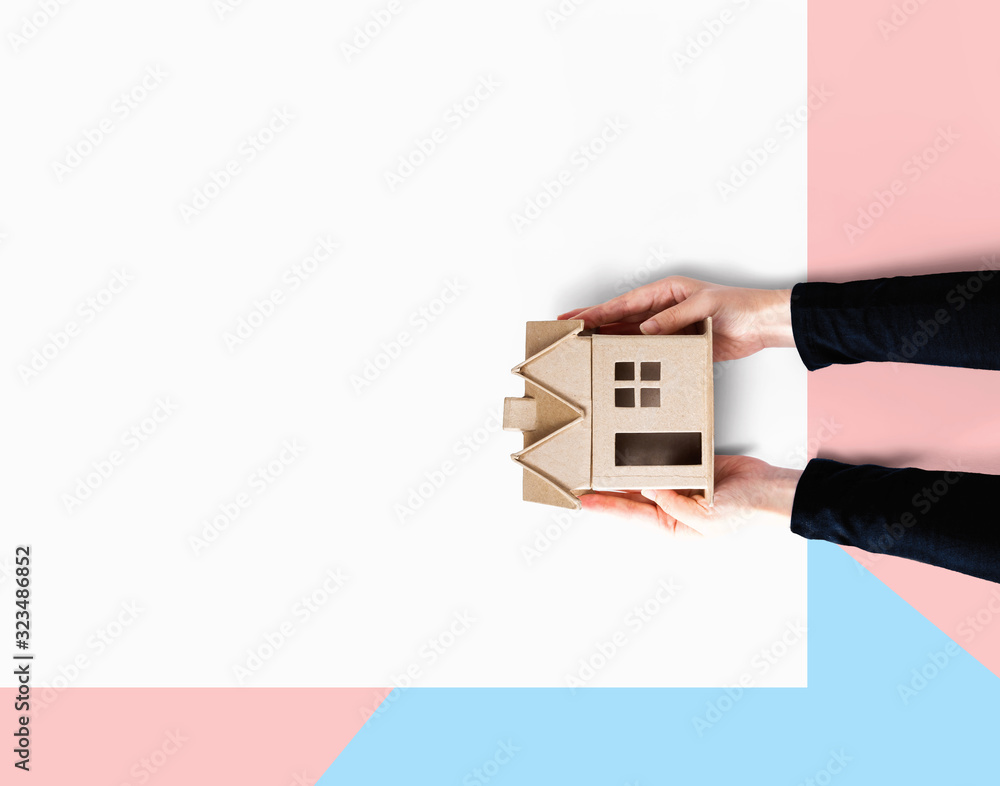 Woman holding a cardboard house overhead view