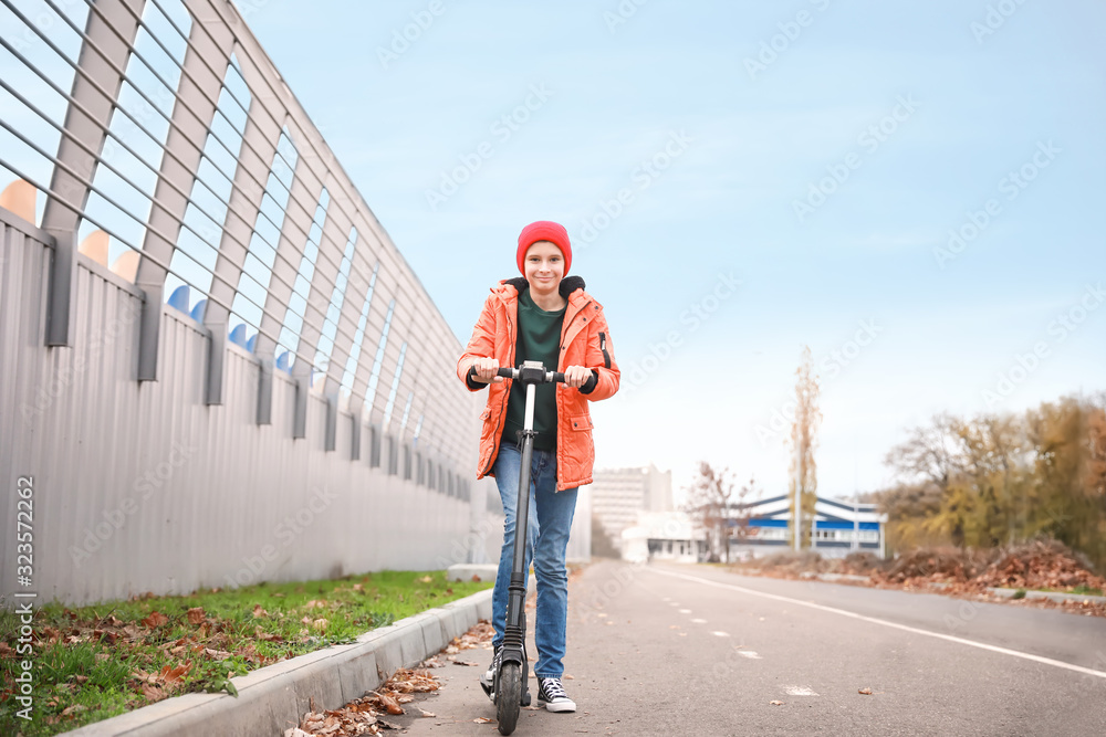 青少年男孩在户外骑脚踏滑板车