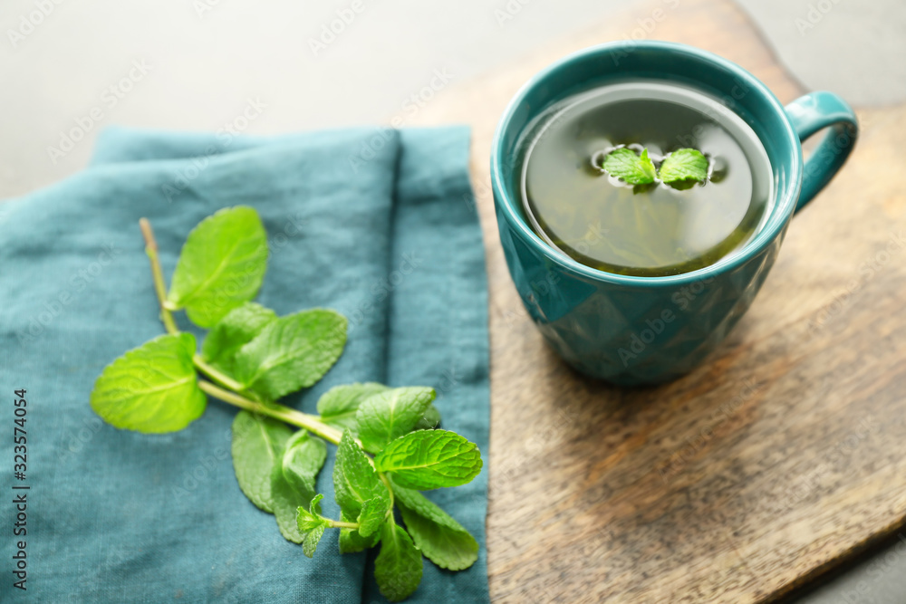 Cup of hot tea with mint on table