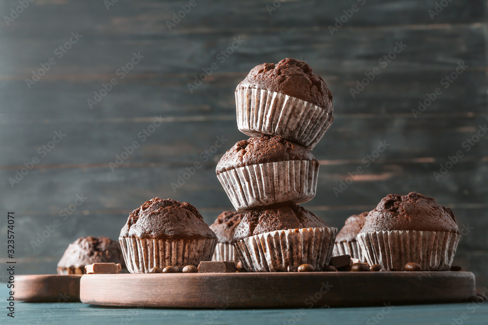 Board with tasty chocolate muffins on table