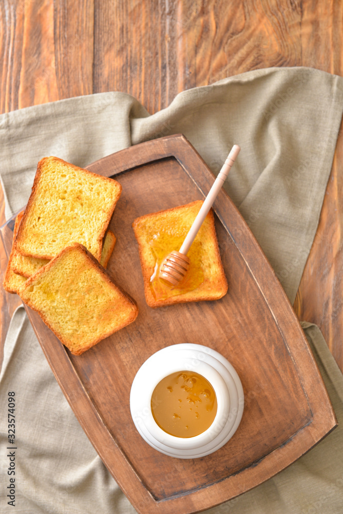 Sweet honey and toasted bread on table