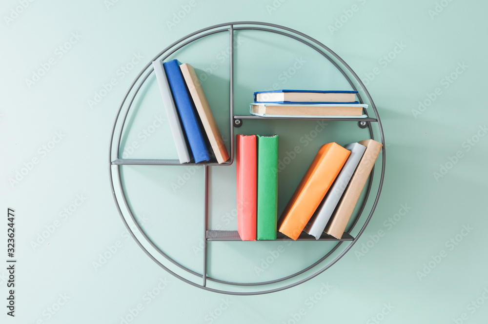 Shelf with books on color wall