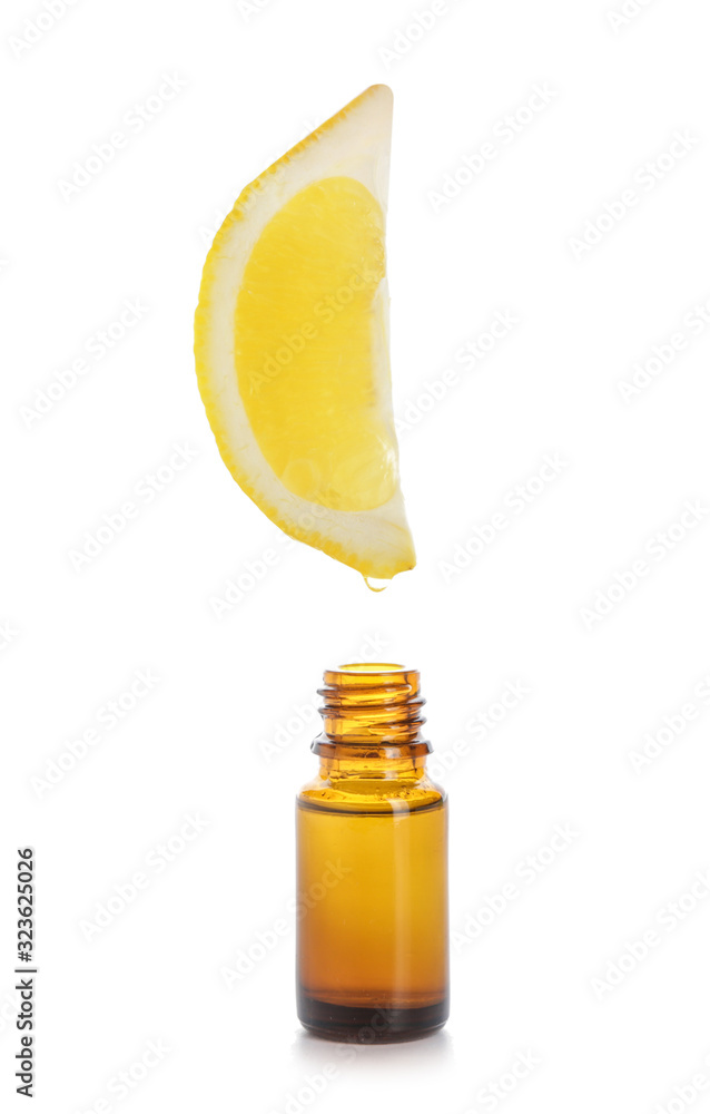 Essential oil dripping from lemon slice into bottle on white background