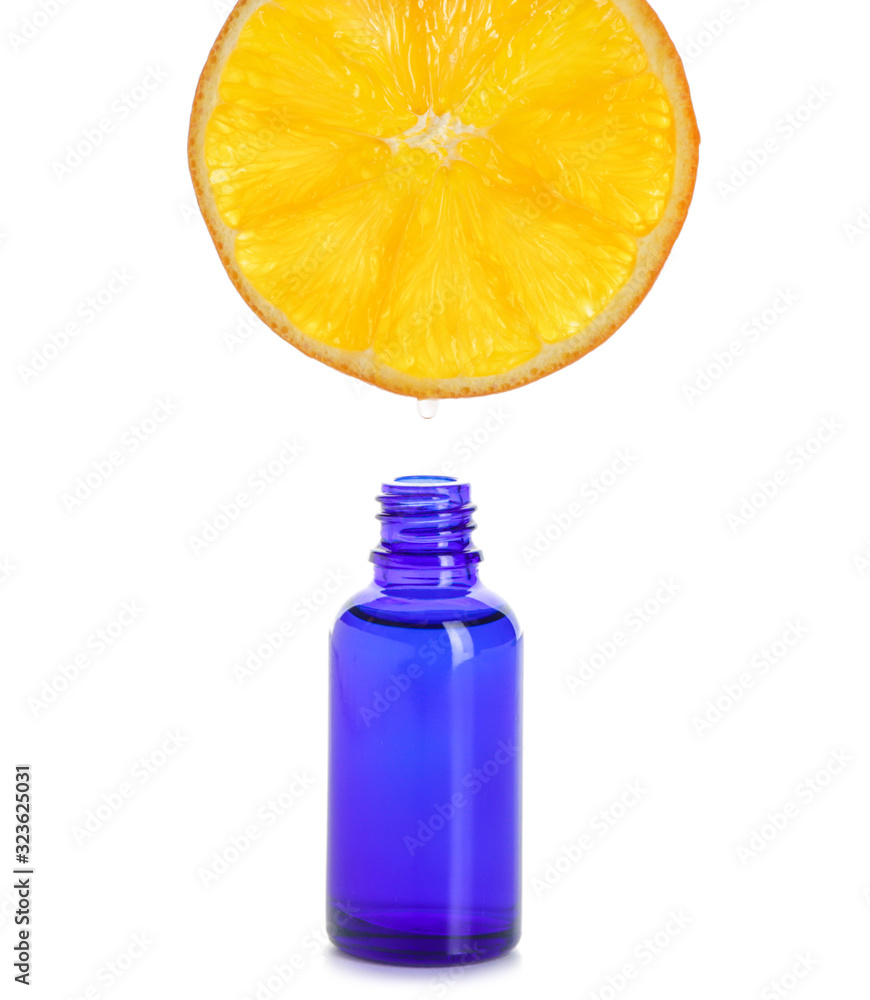 Essential oil dripping from orange slice into bottle on white background