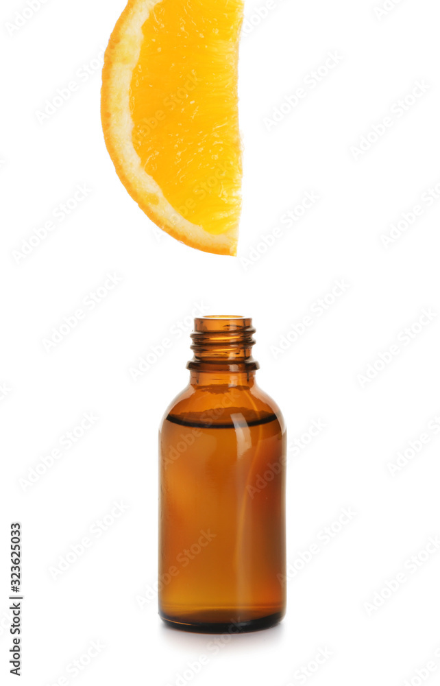 Essential oil dripping from orange slice into bottle on white background