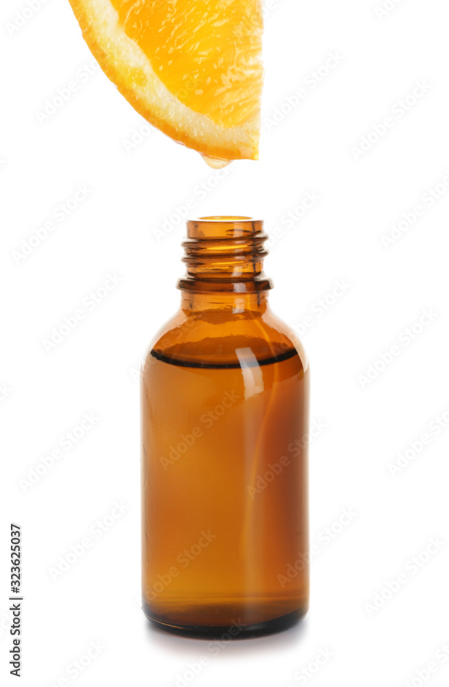 Essential oil dripping from orange slice into bottle on white background