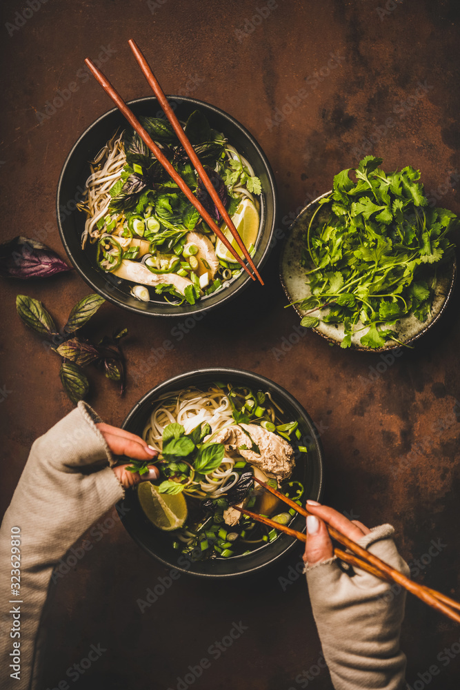 Asian cuisine lunch. Flat-lay of Vietnamese rice noodle chicken soup Pho Ga with cilantro, soy sprou