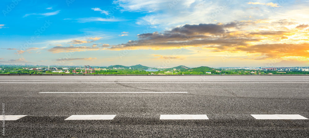 Wide asphalt highway and city suburb skyline in Shanghai at sunset,panoramic view.