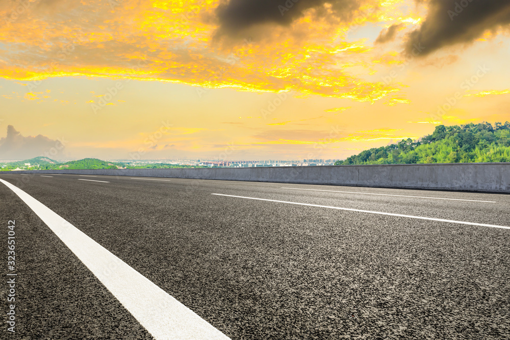 Empty asphalt highway and city suburb skyline in Shanghai at sunset.