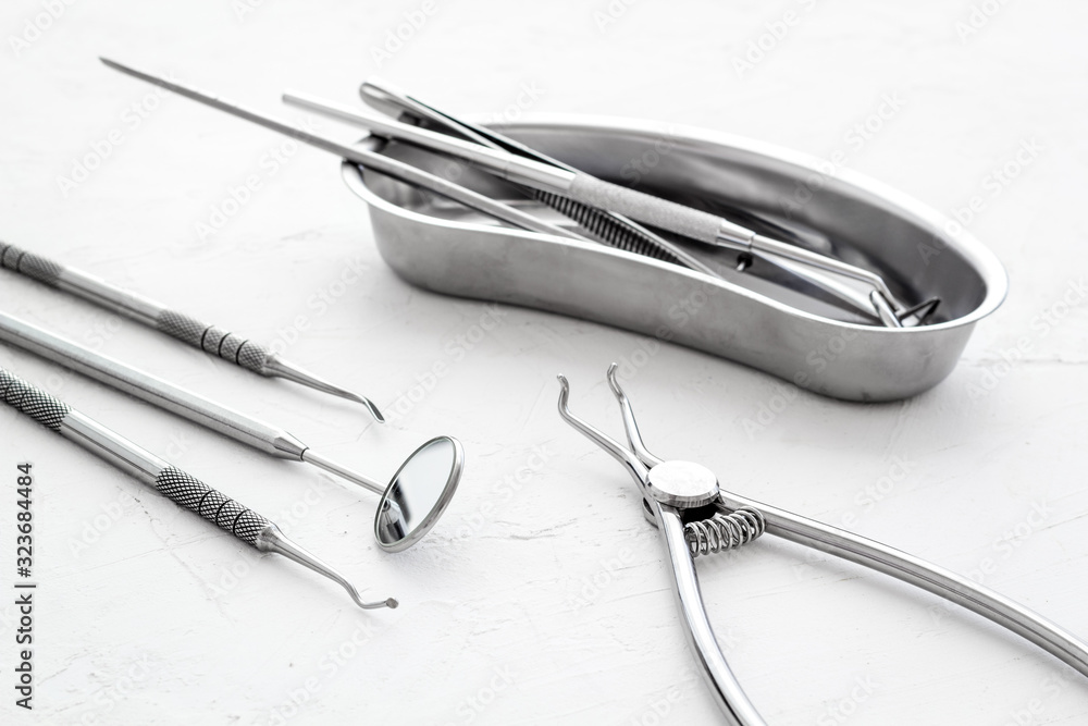 Dental instruments in stainless steel tray on white background close up