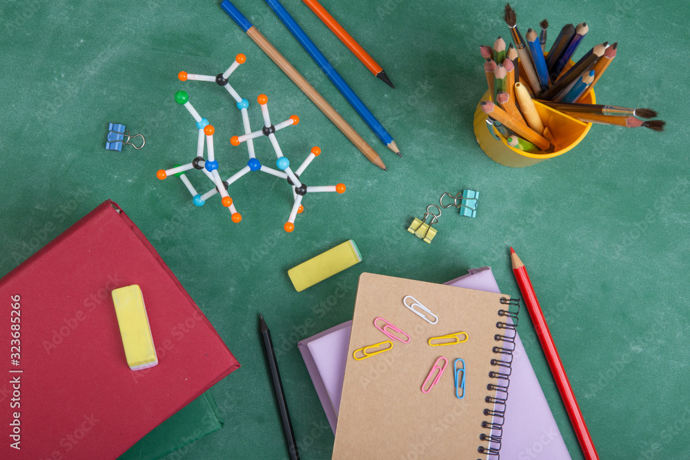 Education concept - books and molecule model on the desk in the auditorium