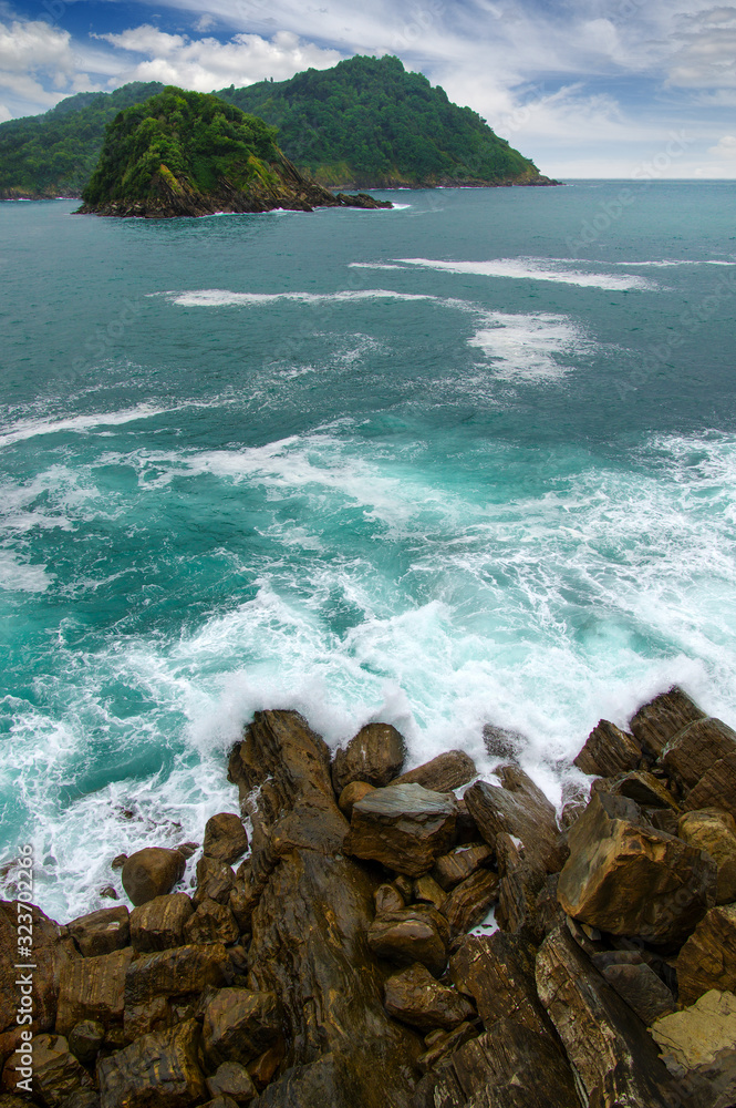 Ocean wave crashing on rock in the bay