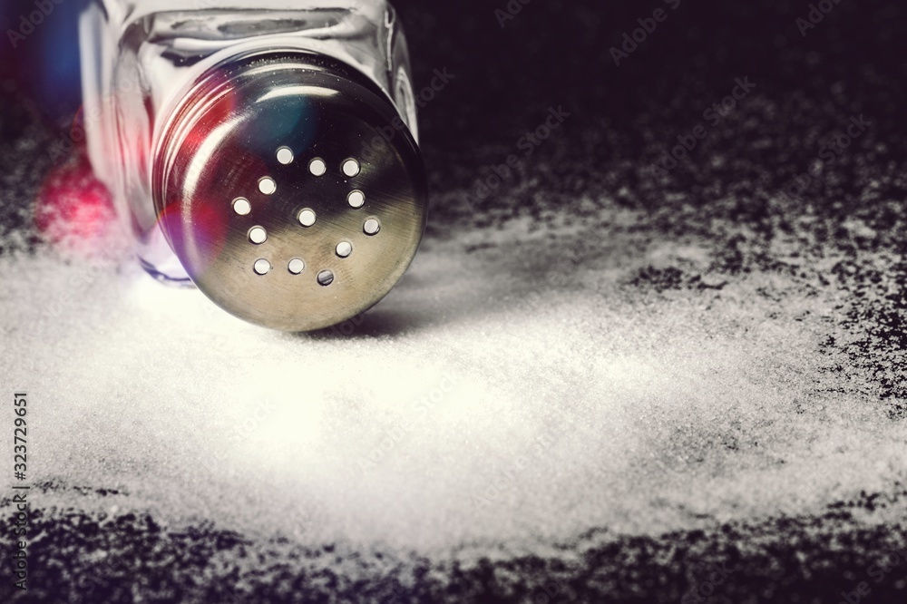 Pouring salt from the salt shaker on desk