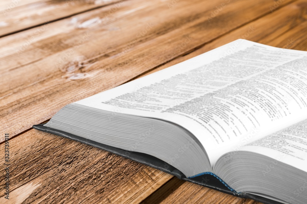 Open old book on wooden desk