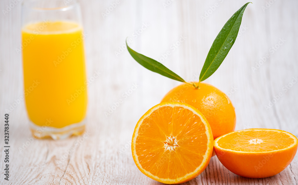 Natural fresh fruit oranges in a wooden background backdrop, half cut oranges, orange juice, vitamin