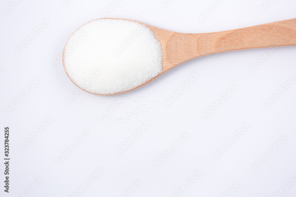 Brown sugar in a wooden spoon on a white background, healthy sugar. Used for cooking or desserts.