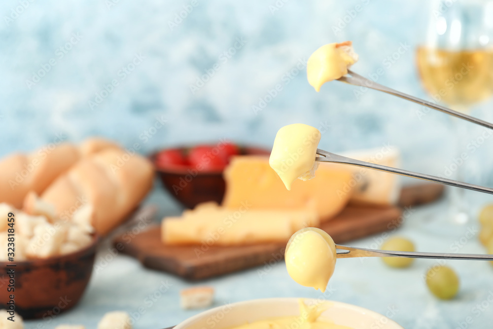 Croutons and grape dipped into cheese fondue, closeup