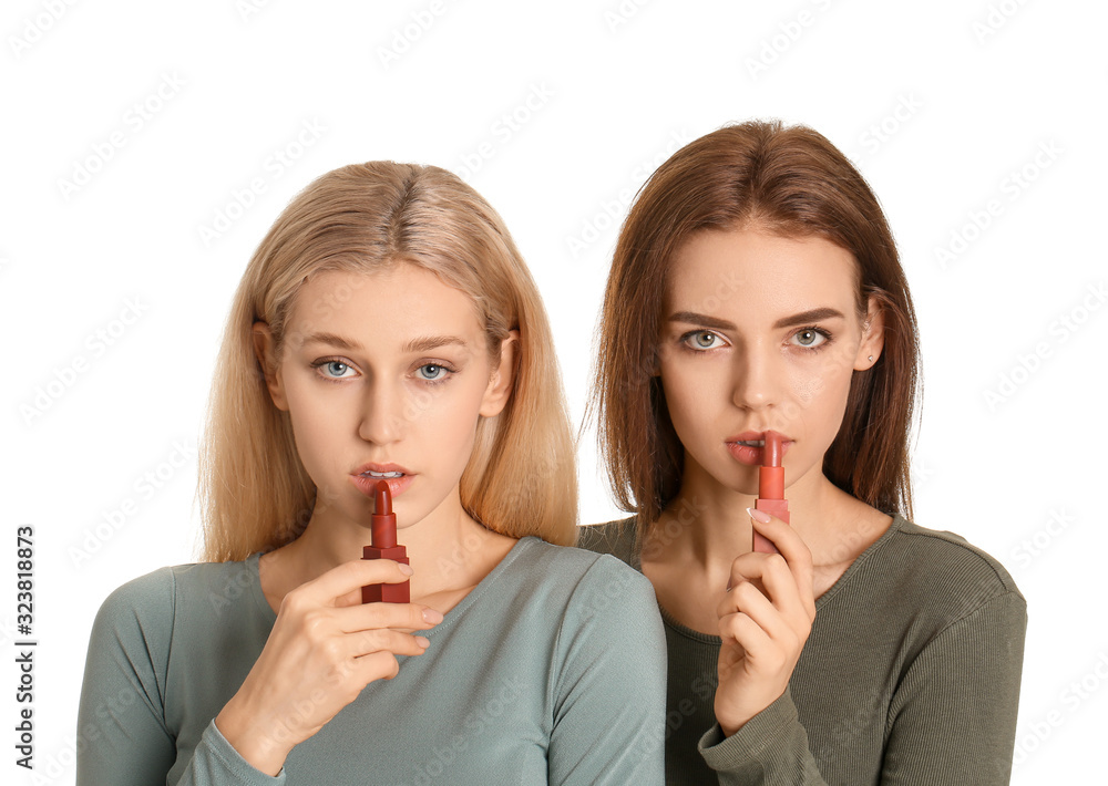 Beautiful young women applying makeup on white background